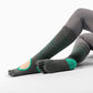 Woman practicing yoga in over-calf grip socks with arch support